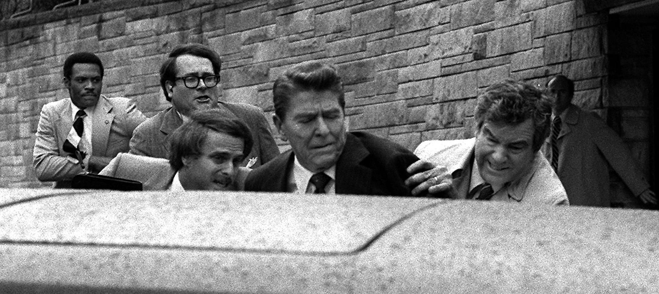 FILE - In this March 30, 1981 file photo, U.S. President Ronald Reagan is shown being shoved into the President's limousine by secret service agents after being shot outside a Washington hotel. Secret service agent Jerry Parr, in raincoat to the right of Reagan, who pushed Reagan into the limousine, was credited with saving President Ronald Reagan&#x2019;s life.