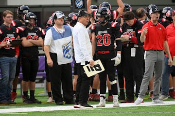 Coach Dean Aurich, center, prepared running back Sam Dennis (20) during Mayer Lutheran's state championship victory in 2021.