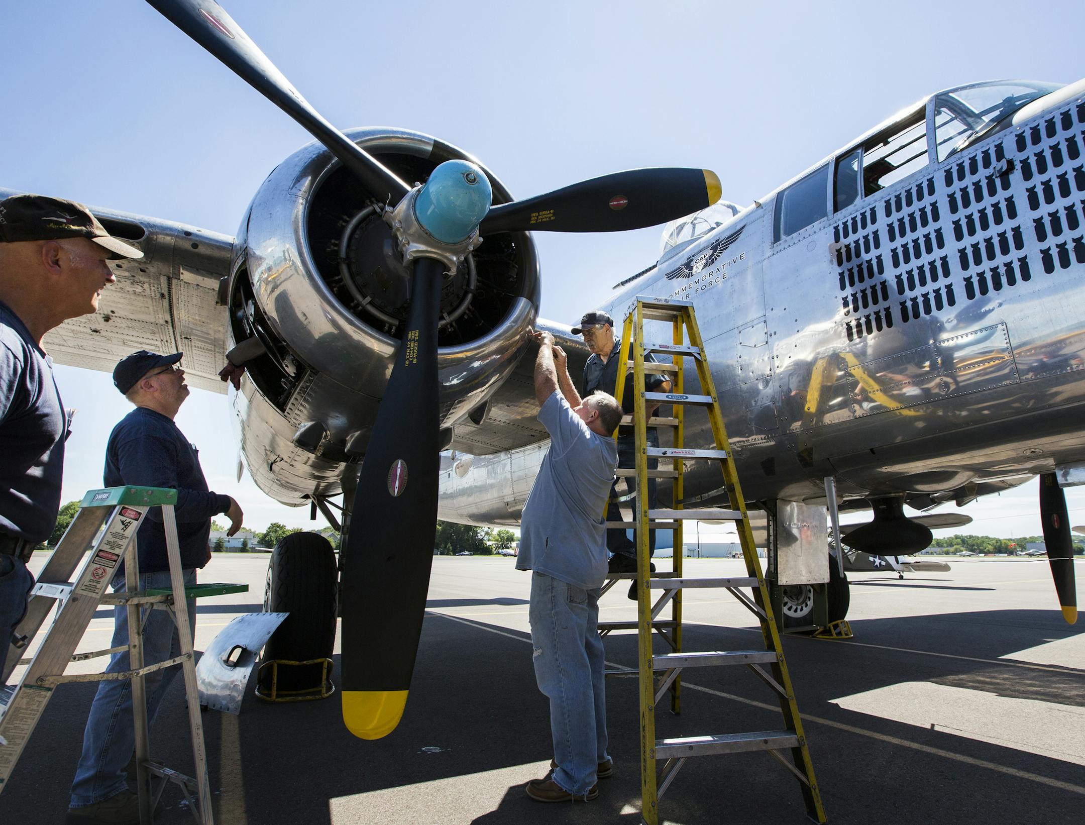 Volunteer mechanics with the Commemorative Air Force Minnesota Wing work on the engine of a B-25 Mitchell plane from 1944 at their hangar in the South St. Paul Airport. From left is Roger VanRanst, Dale Place, Mark Masters and Larry Utter. ] (Leila Navidi/Star Tribune) leila.navidi@startribune.com BACKGROUND INFORMATION: Wednesday, July 6, 2016 at the South St. Paul Airport. South St. Paul city officials are maddened that a former airport manager swindled away nearly $100,000 from an airport the