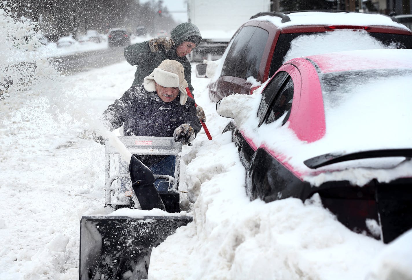 Alfonso Velez front and his son Mark Velez 15, plowed around cars in the 2100 block of Portland Avenue after Saturdays blizzard Sunday April 15, 2018 in Minneapolis, MN. JERRY HOLT &#xef; jerry.holt@startribune.com