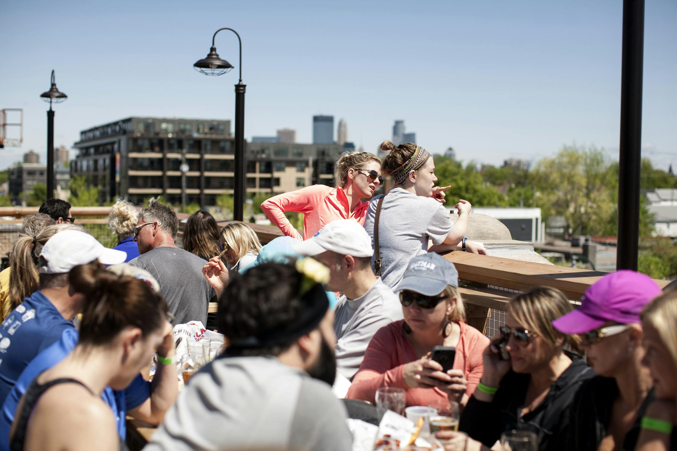 Rebecca Kopacek, left, and Laura Neary look out over Lyndale Avenue on the rooftop patio at LynLake Brewery in Minneapolis May 9, 2015. They had just completed a 5K run with the MN Brewery Running Series. (Courtney Perry)