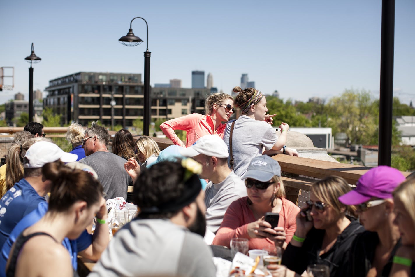 Rebecca Kopacek, left, and Laura Neary look out over Lyndale Avenue on the rooftop patio at LynLake Brewery in Minneapolis May 9, 2015. They had just completed a 5K run with the MN Brewery Running Series. (Courtney Perry)