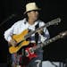 With his electric guitar still strapped on, Carlos Santana began a song early in his set on an acoustic guitar Thursday night at the Mystic Amphitheat