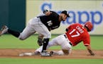 Chicago White Sox second baseman Yoan Moncada (10) tags out Texas Rangers' Shin-Soo Choo (17) on a stolen-base attempt during the first inning of a ba