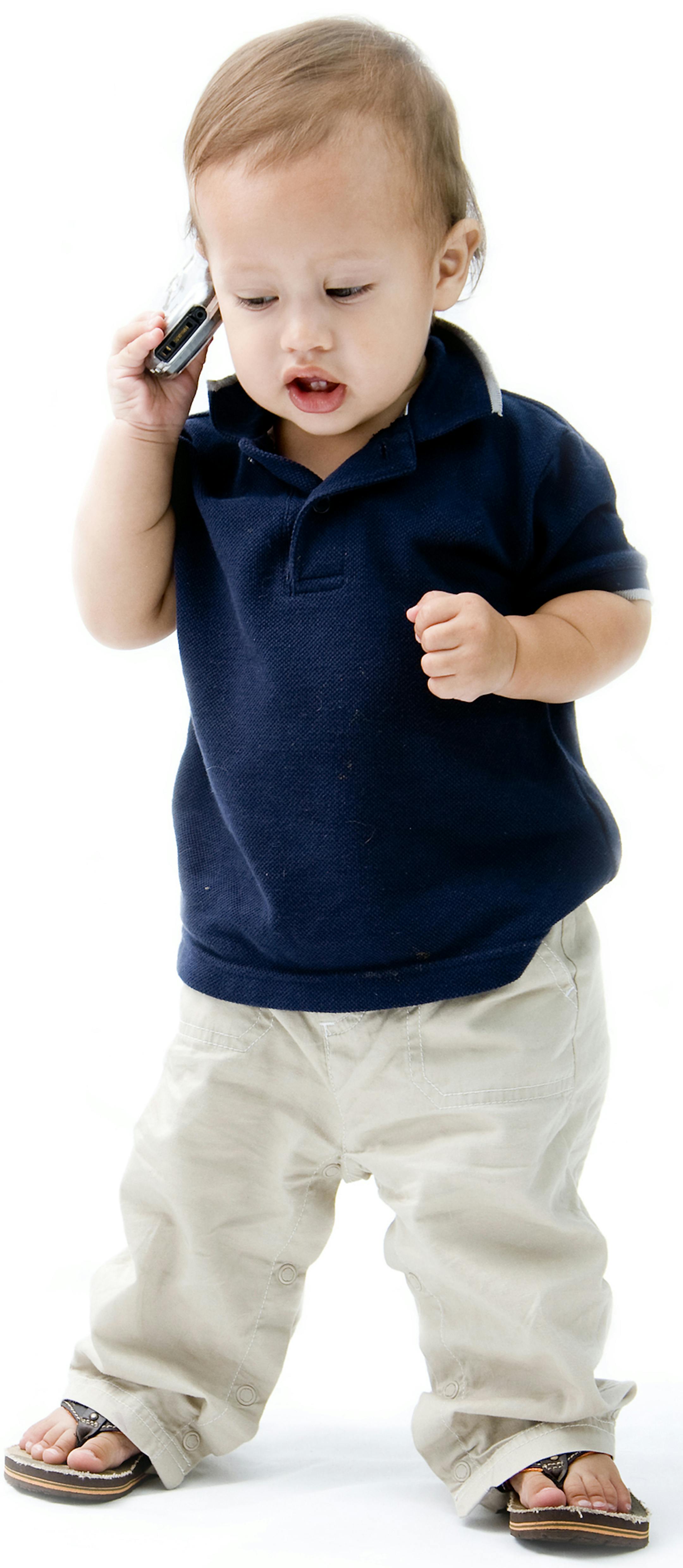 Baby standing with phone in hand calling, isolated