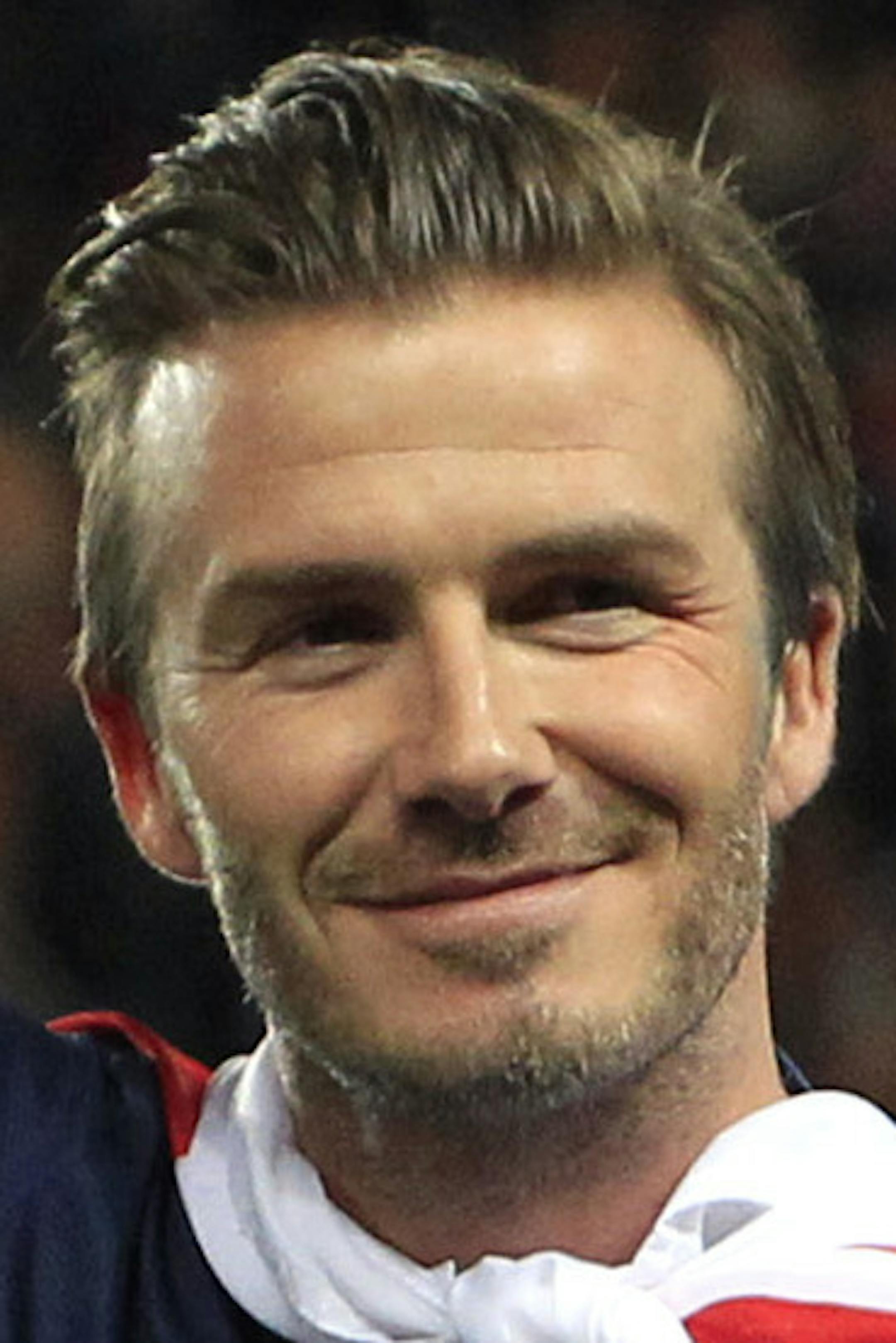 Paris Saint-Germain's midfielder David Beckham from England, center, waves at supporters surrounded by his sons, Brooklyn, second from left, Cruz, left, and Romeo James, right, as he celebrates PSG's French League One title, at the Parc des Princes stadium, in Paris, Saturday, May 18, 2013. The match was his final home game for Paris Saint-Germain before retirement. (AP Photo/Thibault Camus) ORG XMIT: MIN2013051818263624