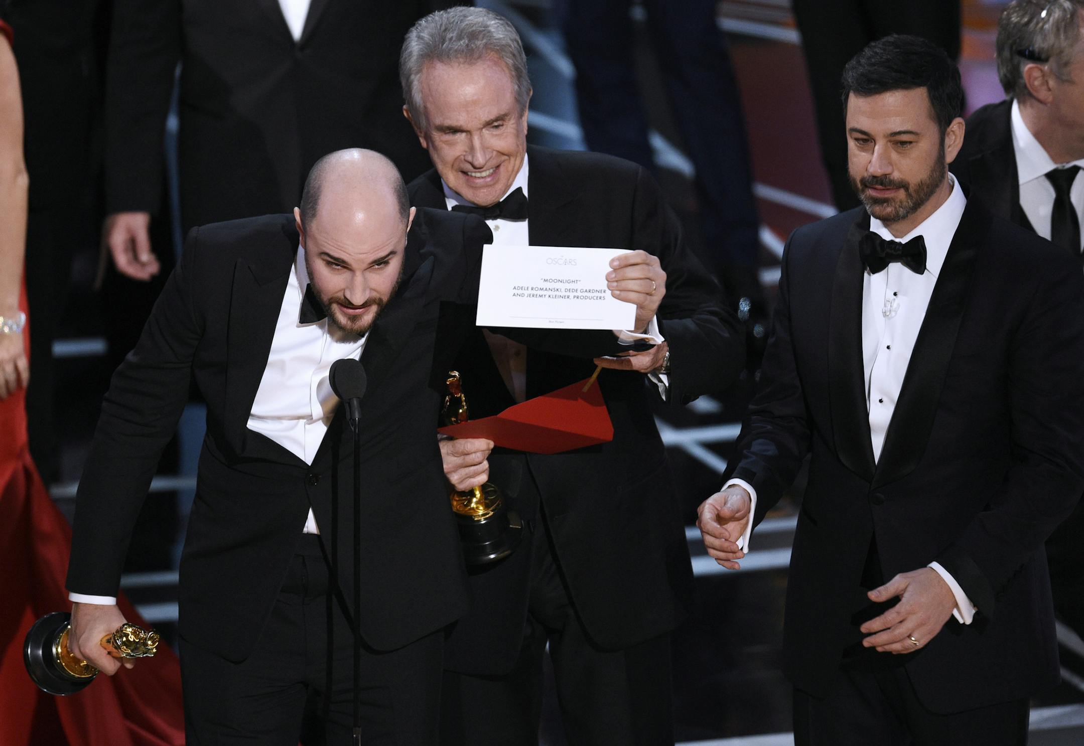 Jordan Horowitz, producer of "La La Land," shows the envelope revealing "Moonlight" as the true winner of best picture at the Oscars on Sunday, Feb. 26, 2017, at the Dolby Theatre in Los Angeles. Presenter Warren Beatty and host Jimmy Kimmel look on from right. (Photo by Chris Pizzello/Invision/AP)