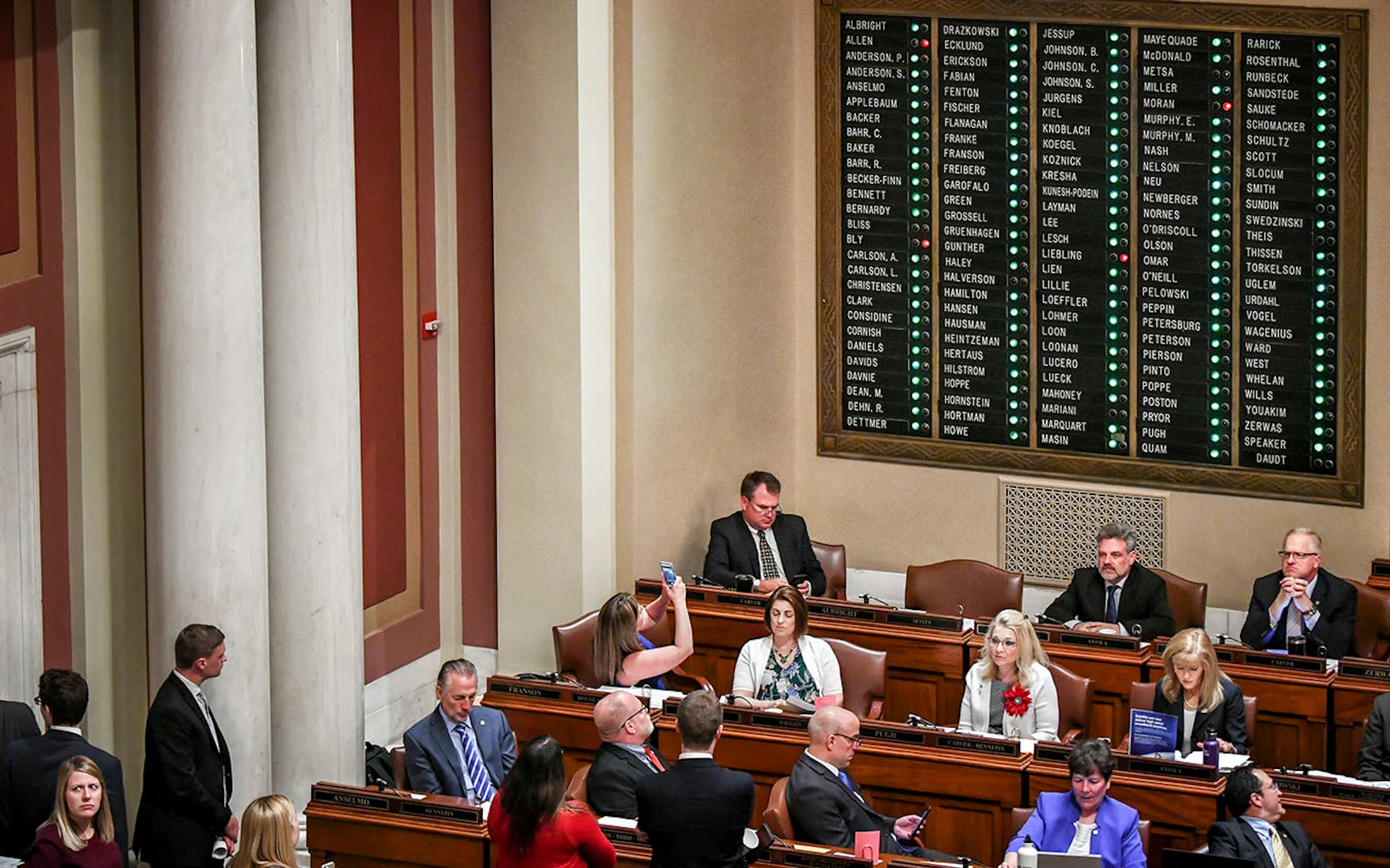 Representative Mary Franson, R-Alexandria, center, photographed the vote board as voting closed on her bill which passed by a wide bipartisan margin 124-4 making it a felony for parents to allow it. It now goes to the Senate.