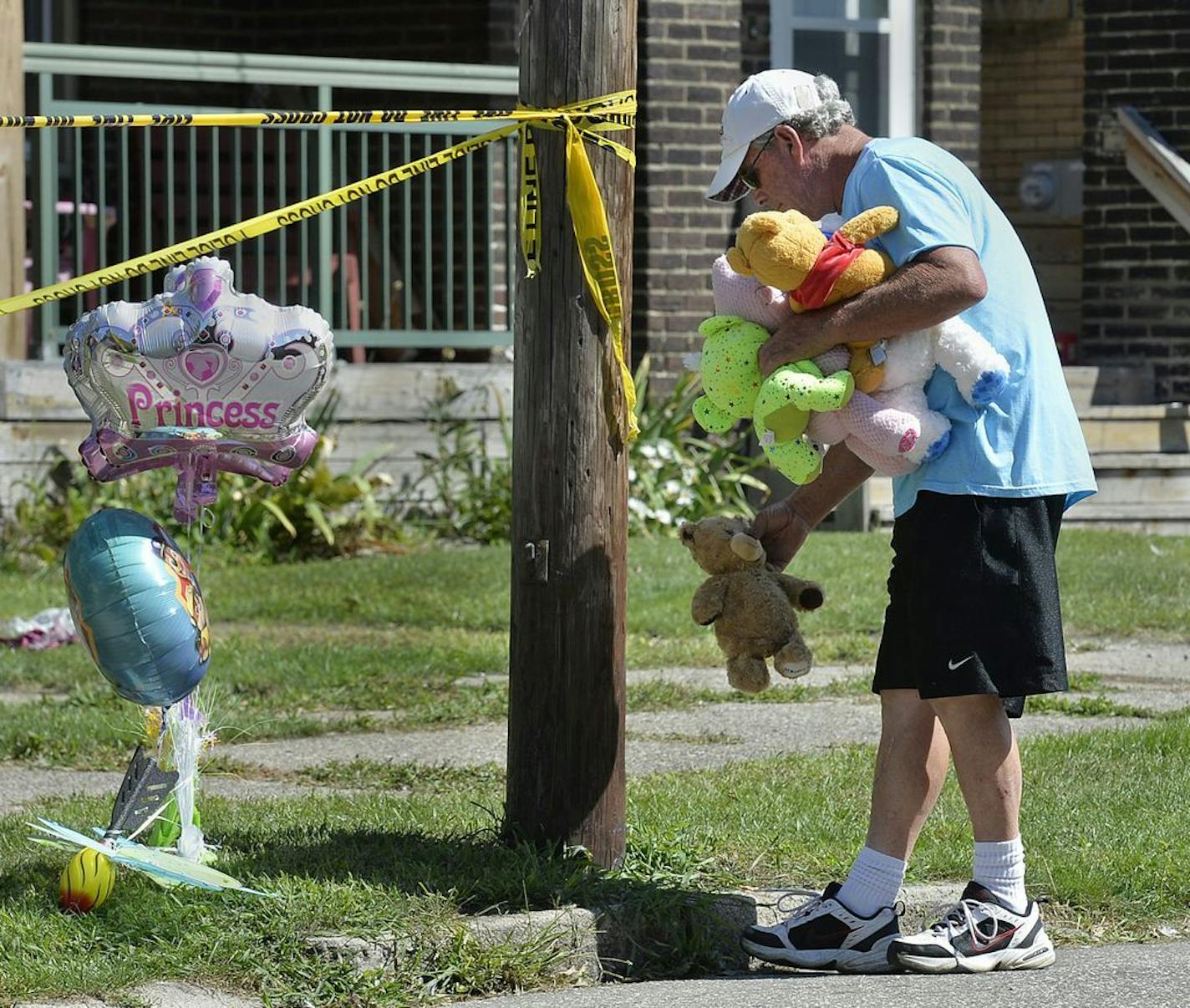 Paul Laughlin, 57, places stuffed animals on Sunday, Aug. 11, 2019 outside a home at 1248 West 11th St. in Erie, Pa., where multiple people died in an early-morning fire.