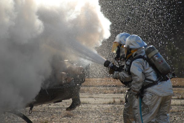 Military firefighters extinguish a helicopter fire during a training exercise in 2007 at Fort Knox. Maplewood-based 3M on Thursday announced a settlem