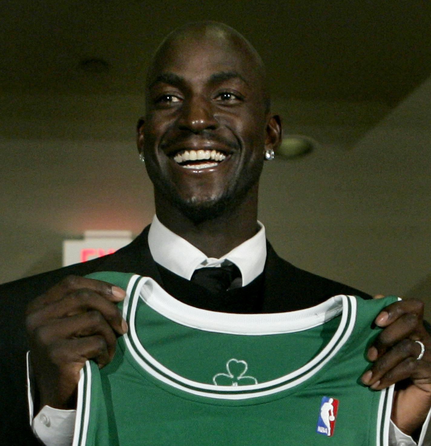 Newly-acquired Boston Celtics forward Kevin Garnett holds up his jersey during a news conference in Boston, Tuesday, July 31, 2007. The Celtics sent the Minnesota Timberwolves forwards Al Jefferson, Ryan Gomes and Gerald Green, guard Sebastian Telfair and center Theo Ratliff, two first-round draft picks and cash considerations in the trade for Garnett.(AP Photo/Steven Senne) ORG XMIT: MACK106