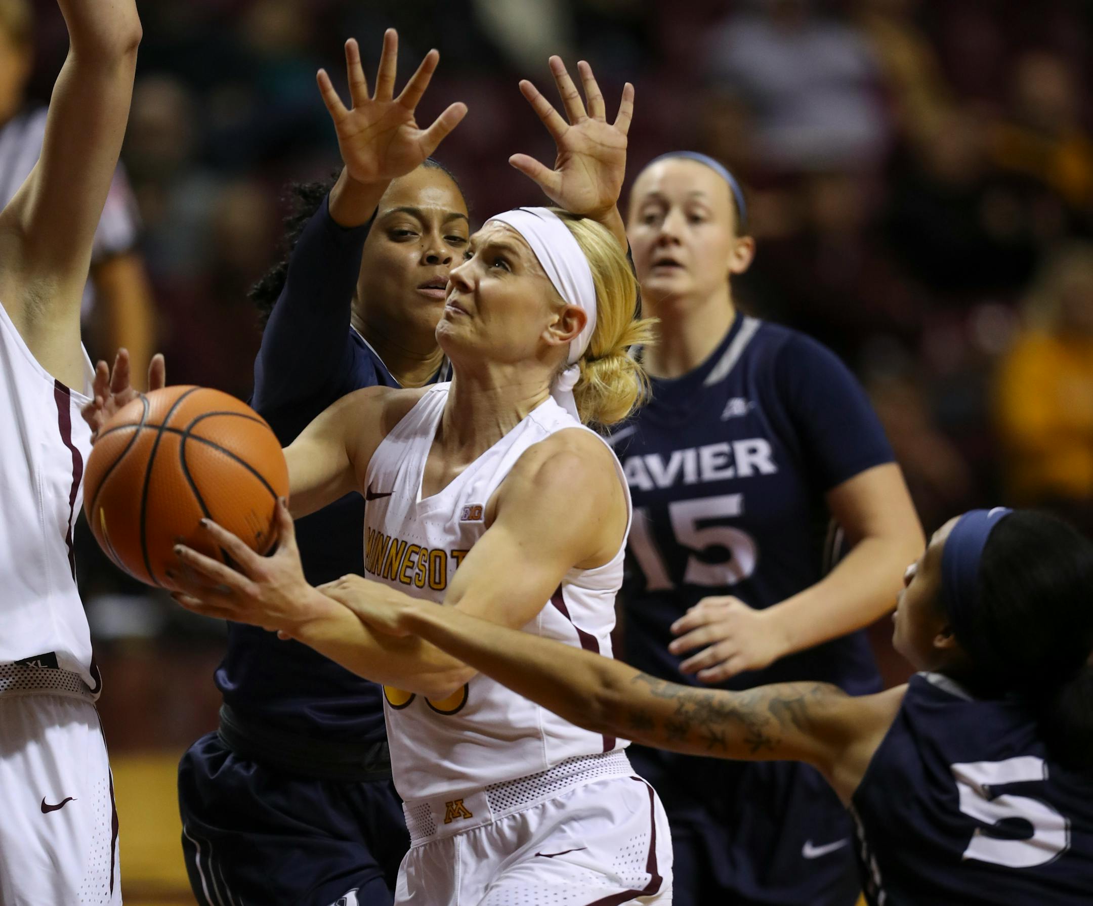Minnesota Gophers guard Carlie Wagner (33) was fouled by Xavier Musketeers guard Princess Stewart (5) as she drove to the net in the first quarter.
