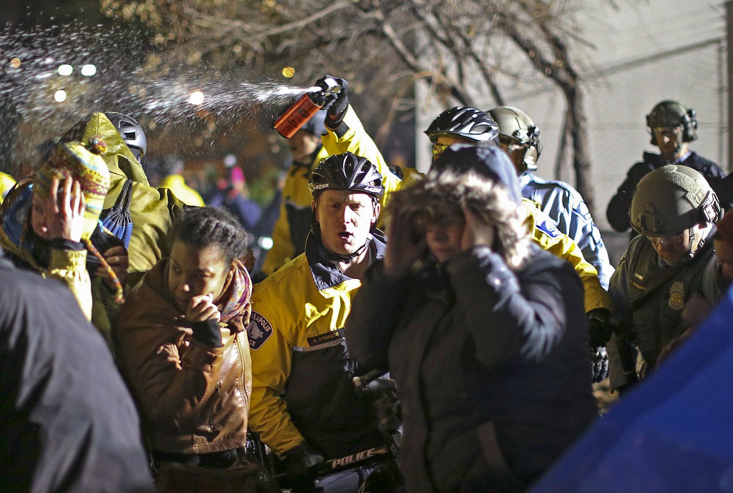 Police sprayed pepper spray to disperse demonstrators from a side entrance to the 4th Precinct headquarters Wednesday night in Minneapolis.