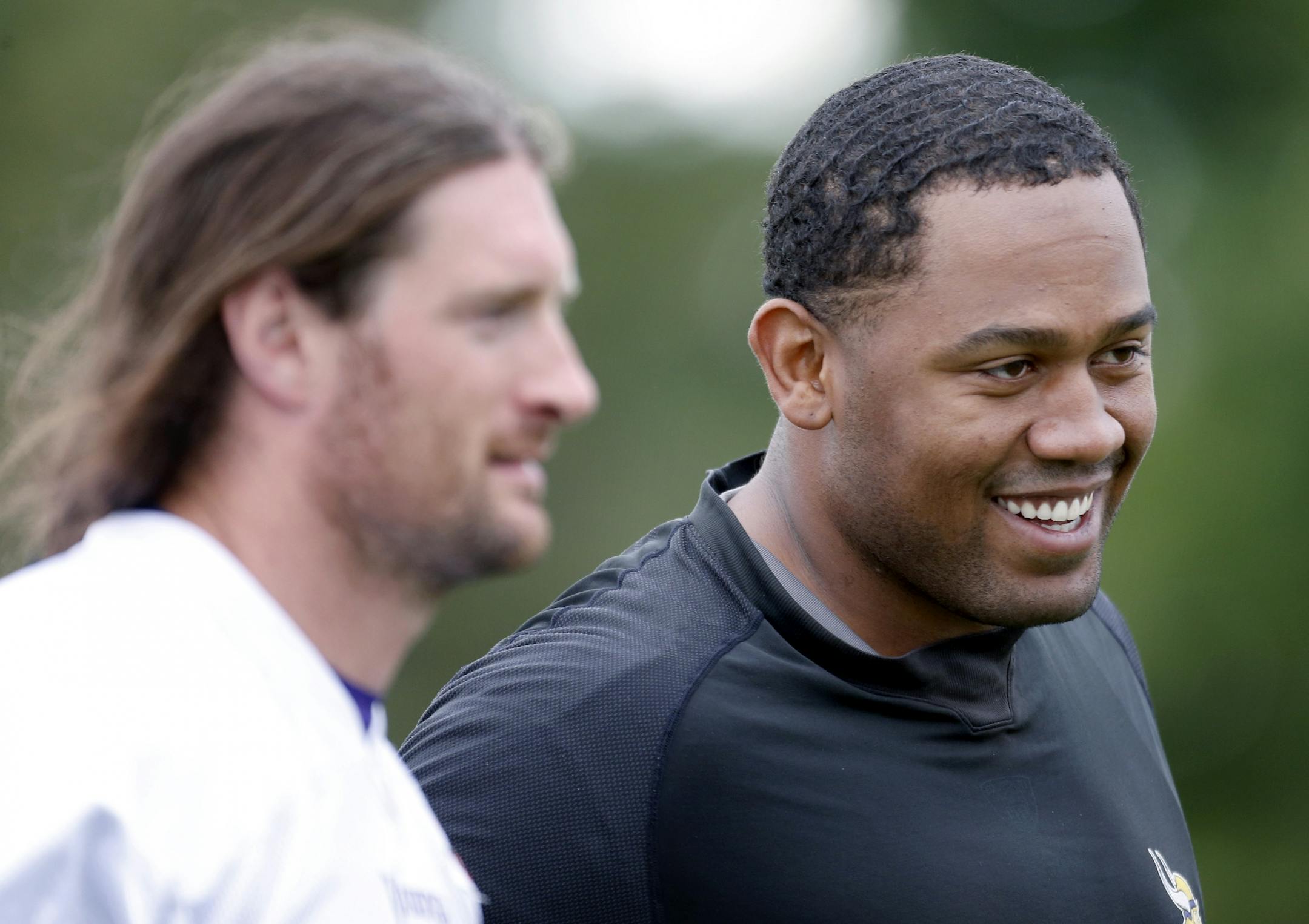 The Vikings' Kevin Williams (right, with fellow defensive lineman Brian Robison) took a pay cut, but he's still determined to play at a high level.