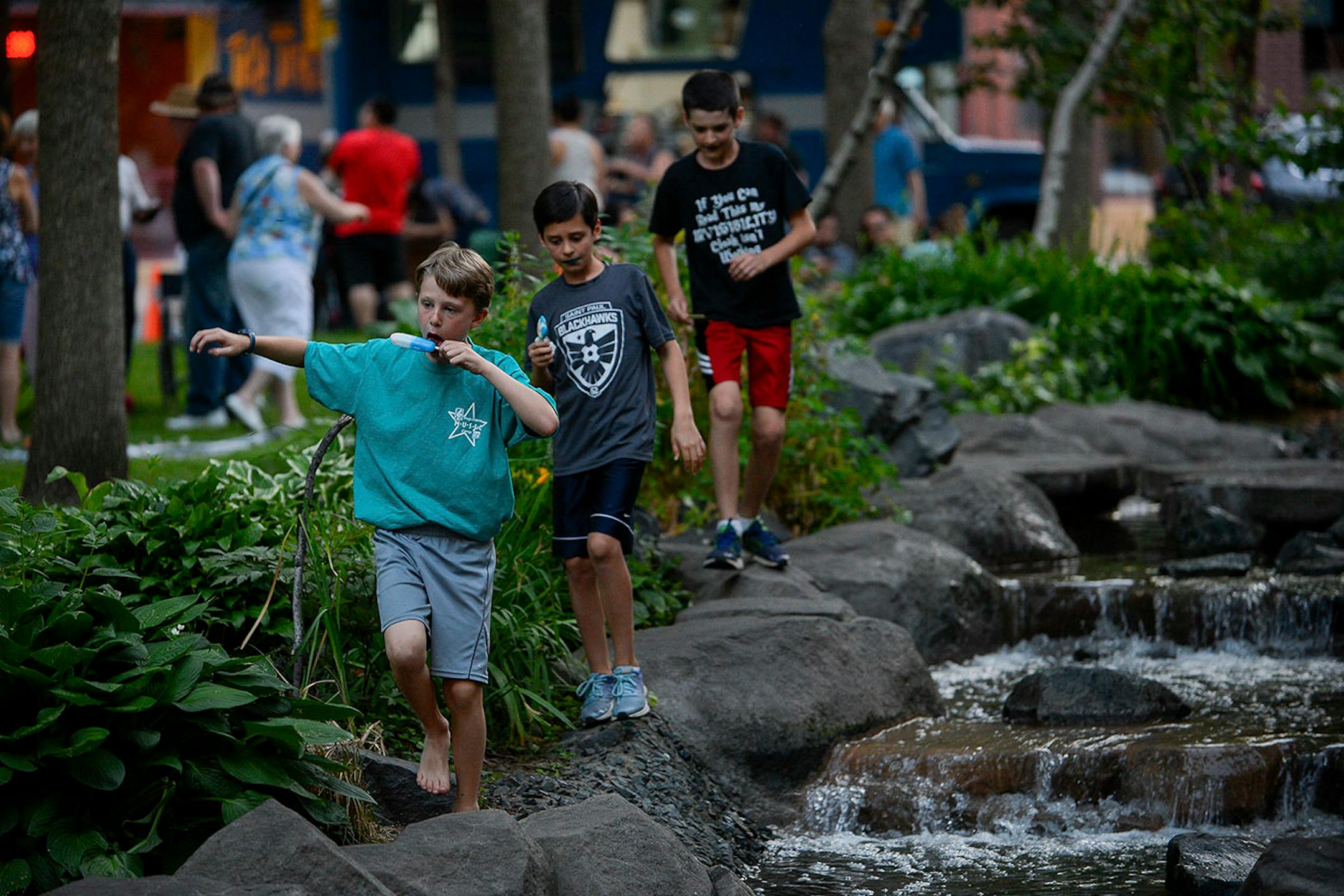 A group of friends from St. Paul walked the rock edge along the creek at Mears Park Thursday night as live music was performed nearby.
