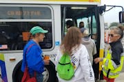 Metro Transit employee Danielle Julkowski, in the yellow vest, directed passengers to a State Fair express bus at the County Road 73 Park and Ride in 