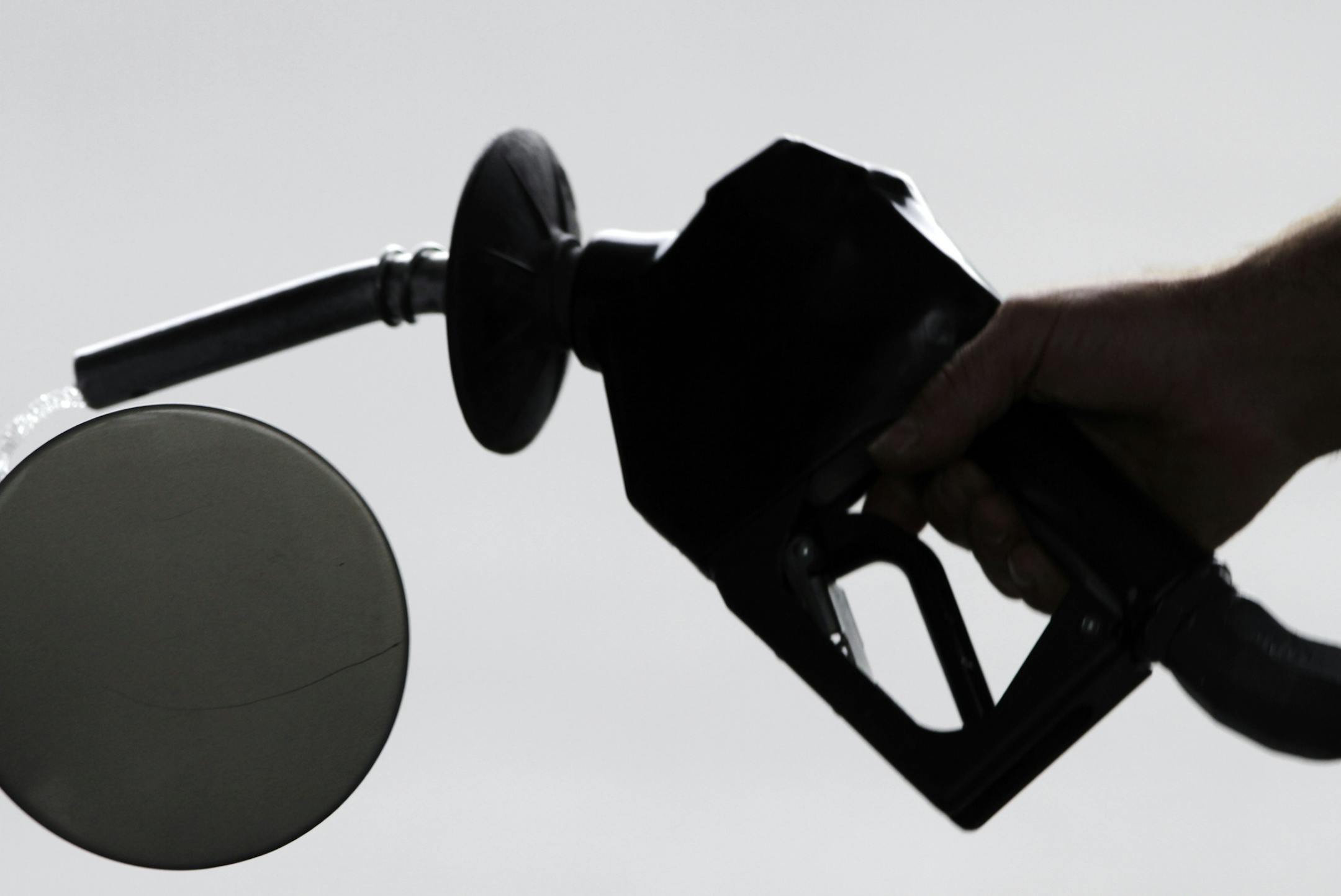 In this Aug. 15, 2011 photo, a motorist pulls the nozzle out of his gas tank after fueling his car at a station in Augusta, Maine. For the first time in months, retail gasoline prices have fallen below $3 a gallon in places, including parts of Michigan, Missouri and Texas. And the relief is likely to spread thanks to a sharp decline in crude-oil prices. (AP Photo/Pat Wellenbach) ORG XMIT: MIN2014070220120245