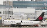 Air Canada Boeing 737 palne is parked next to a gate at Trudeau Airport in Montreal.