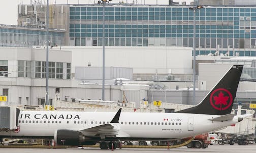 Air Canada Boeing 737 palne is parked next to a gate at Trudeau Airport in Montreal.