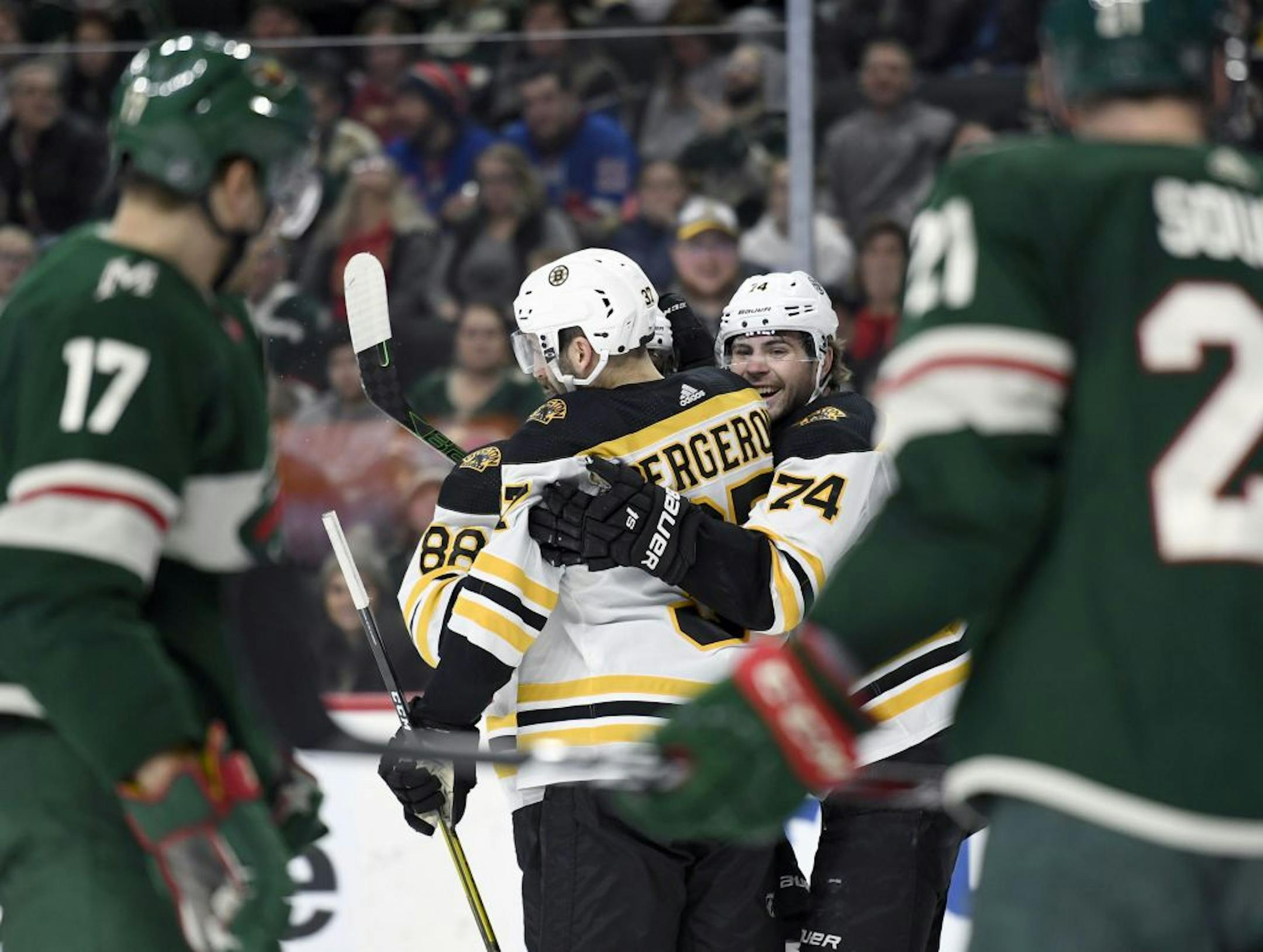 Boston Bruins' Patrice Bergeron (37) and Jake DeBrusk (74) congratulate right wing David Pastrnak (88) on a goal as the Minnesota Wild watch during the second period of an NHL hockey game Saturday, Feb. 1, 2020, in St. Paul, Minn. (AP Photo/Hannah Foslien) ORG XMIT: MER18a68f1204e5580784207ec37ba9e