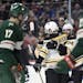 Boston Bruins' Patrice Bergeron (37) and Jake DeBrusk (74) congratulate right wing David Pastrnak (88) on a goal as the Minnesota Wild watch during th