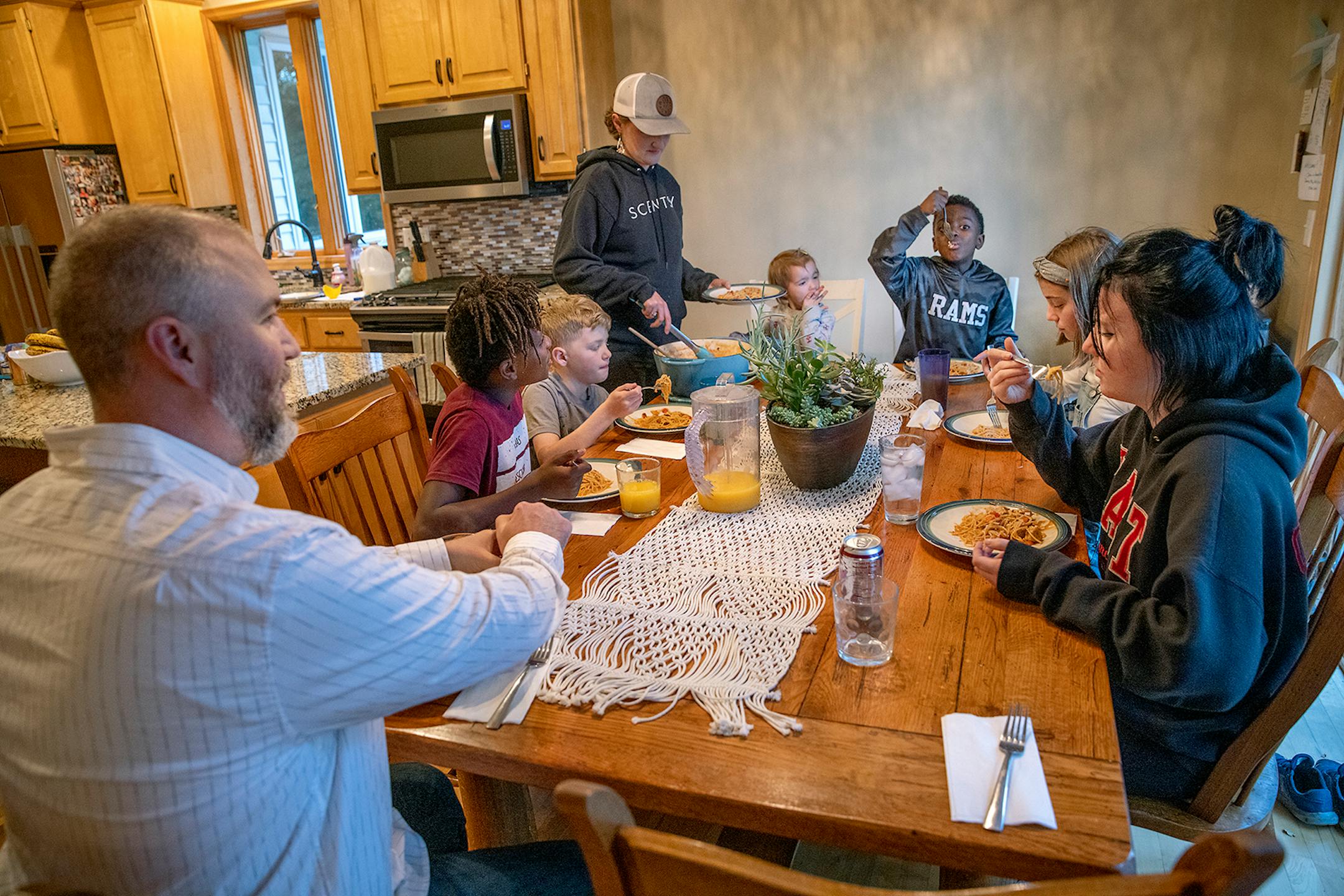 The Lundquist family including from left, Jacob Lundquist, Nelson, 11, Ridge, 9, Kate Lundquist, Verabeth, 2, Maki, 8, Charlotte, 11, and Addi, 14, moved from Roseau, MN to Brooklyn Park after a decision the family made after visiting the George Floyd memorial in June. The family sat for dinner in their new home, Thursday, October 1, 2020 in Brooklyn Park, MN.