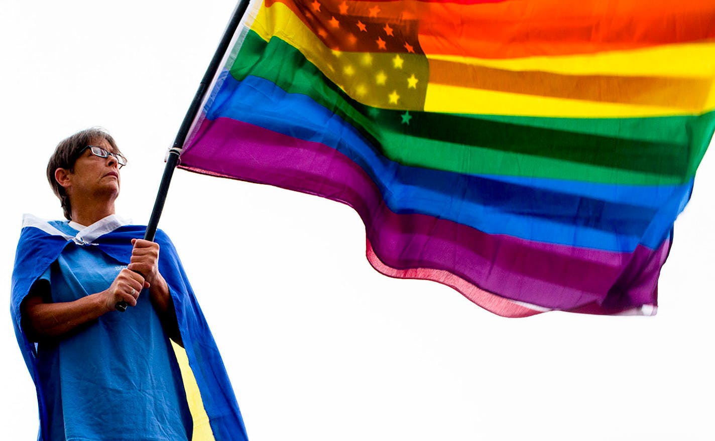 Riz Dunaway of Bowling Green waves a rainbow and American flag together during a rally celebrating the Supreme Court decision on gay marriage.