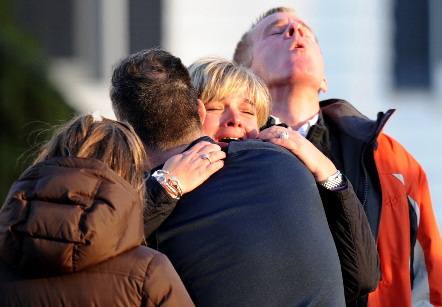 Unidentified people embrace on December 14, 2012 at the aftermath of a school shooting at a Connecticut elementary school that brought police swarming into the leafy neighborhood, while other area schools were put under lock-down, police and local media said.