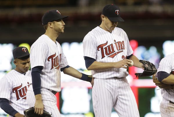 Minnesota Twins pitcher Kevin Correia, right, gets a consoling pat from third baseman Trevor Plouffe as he waits to be taken out in the seventh inning