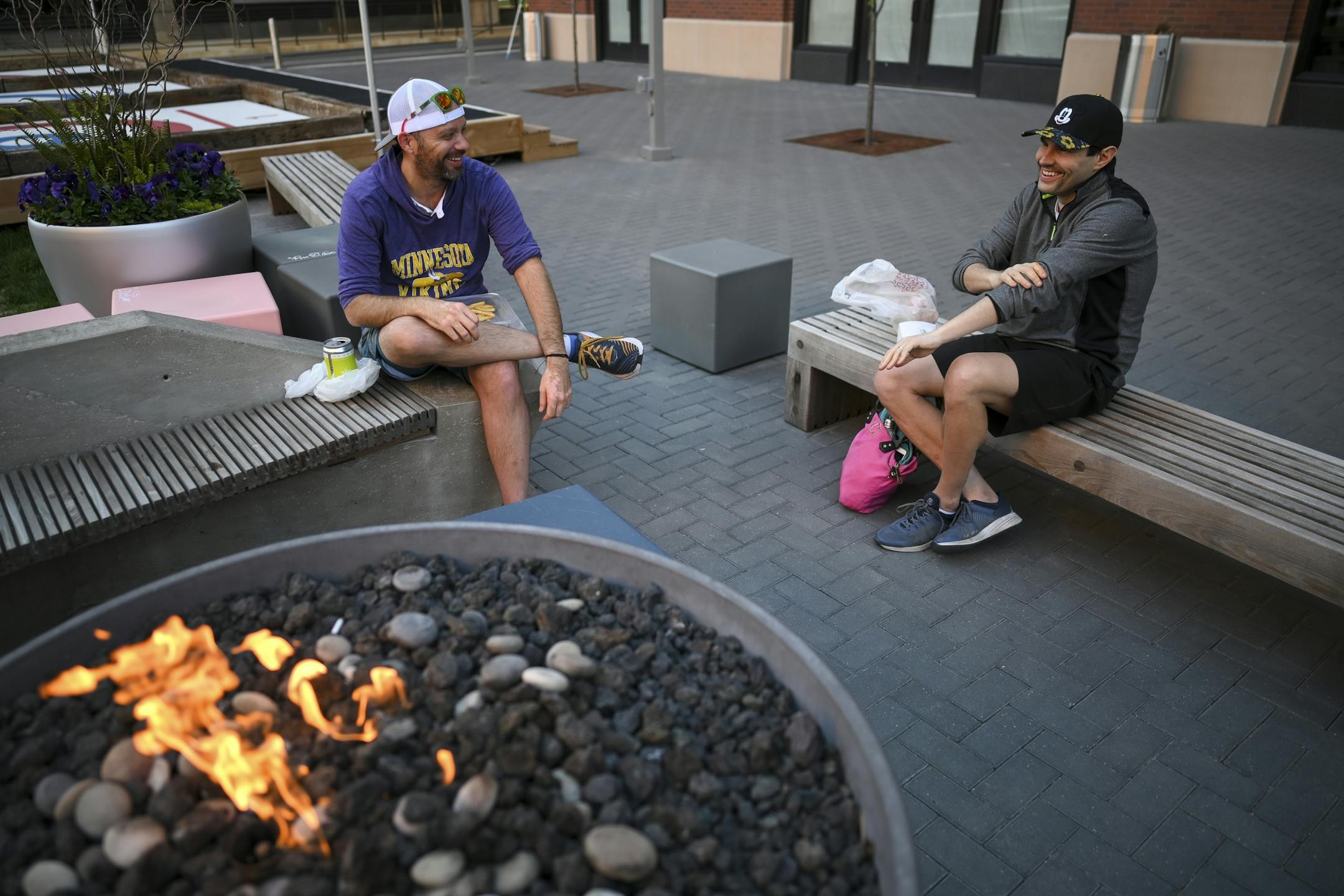 Friends Jon Feustel, left, and Mark Siebenaller, from the North Loop, drank beer and ate pizza from The Freehouse Wednesday in the courtyard outside the brewpub Wednesday night.