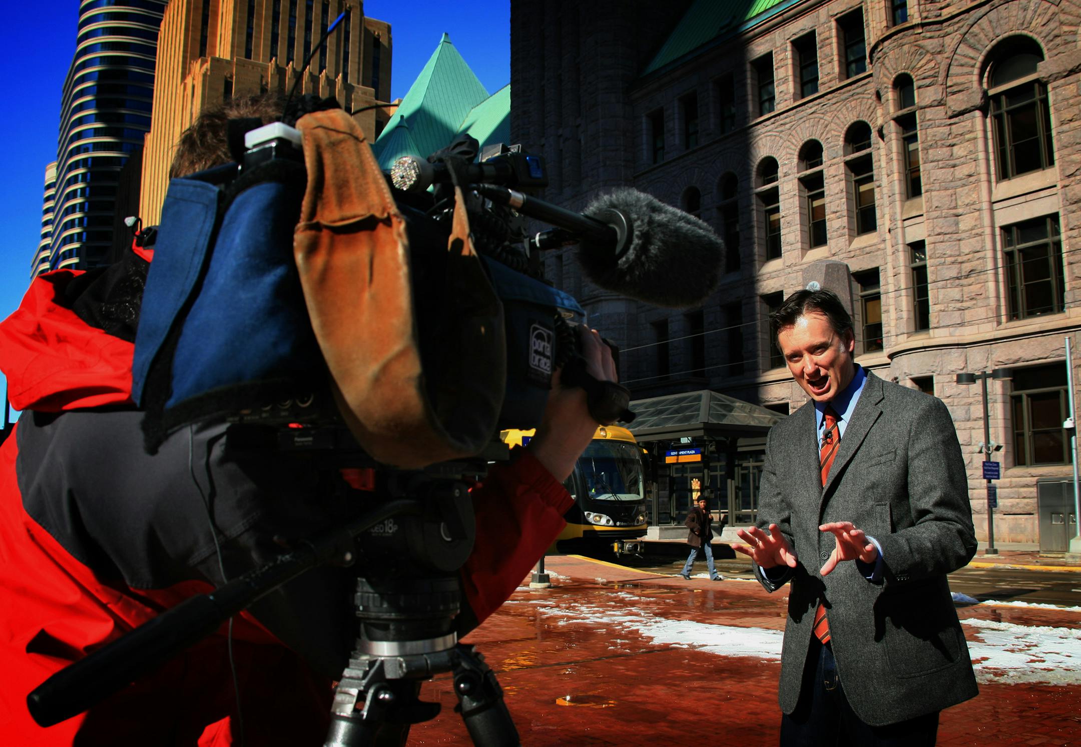 Tom Lyden, Fox 9 news reporter, works with photojournalist Scott Keller work outside Minneapolis city hall on a story involving the Minneapolis police department that was scheduled to run on that evening's news.
