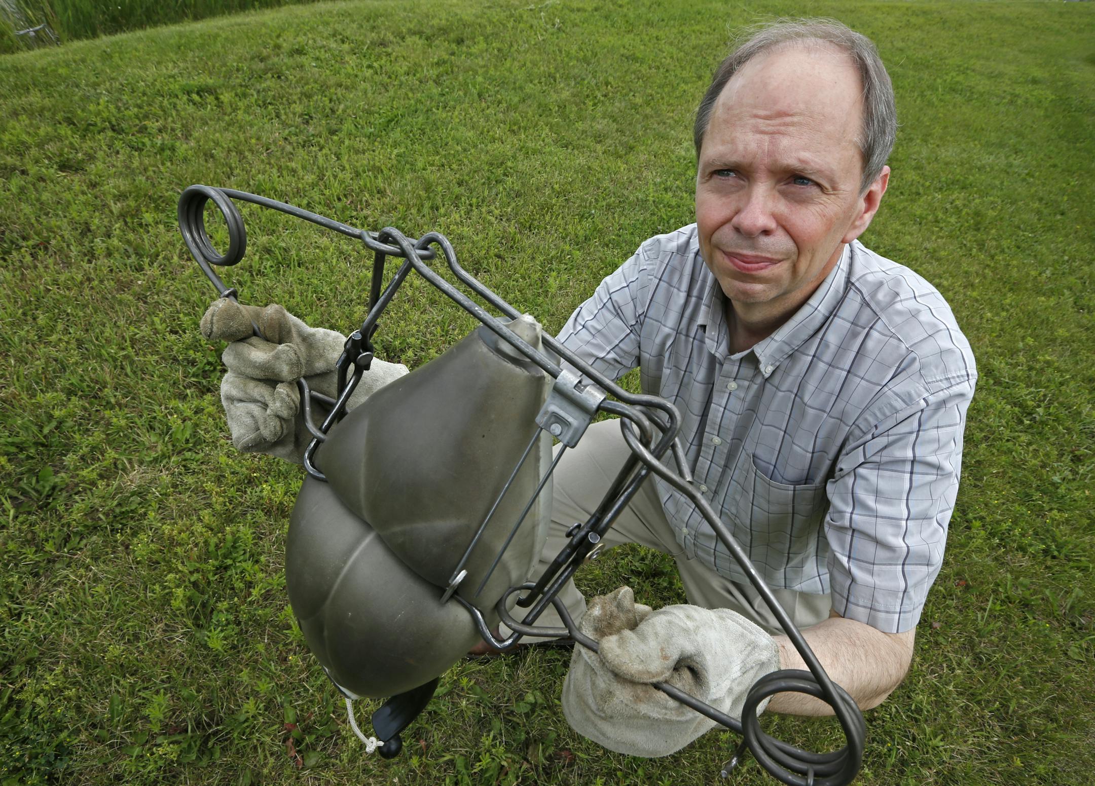 Kevin Auslund demonstrated a Conibear-style trap sprung on a duck decoy, showing the force of the trap when tripped. Kevin Auslund is fighting the DNR's position that trapping is legal for some on the new walk-in hunter access lands. He says that puts hunting dogs in danger.