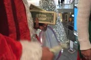 Screen shot from video posted to Ryan Flores' Facebook page of "Santa" throwing cash down on Mall of America shoppers.