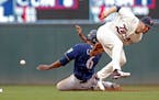 Milwaukee Brewers' Lorenzo Cain, left, slides safely into second after a wild pitch by Minnesota Twins pitcher Fernando Romero and a throwing error by