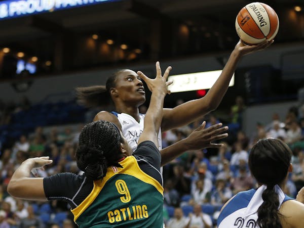 Minnesota Lynx center Sylvia Fowles, center, shoots in front of Seattle Storm center Markeisha Gatling (9) during the first half of a WNBA basketball 
