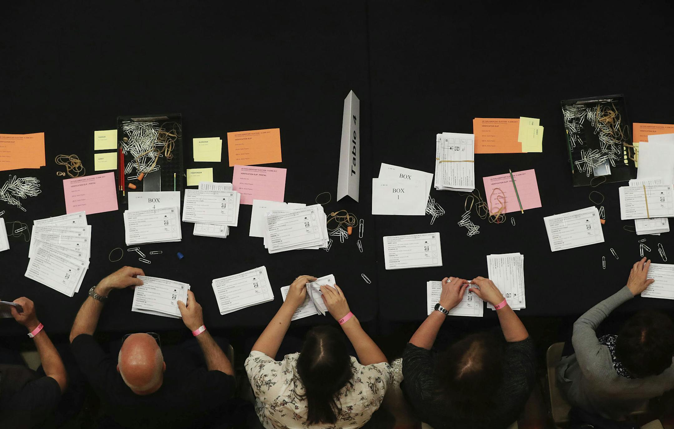 Election staff count ballot papers for the general election inside Kendal Leisure Centre in the Westmorland and Lonsdale constituency in north England, Thursday June 8, 2017. Britain voted Thursday in an election that started out as an attempt by Prime Minister Theresa May to increase her party's majority in Parliament ahead of Brexit negotiations but was upended by terror attacks in Manchester and London during the campaign's closing days. (Danny Lawson /PA via AP)
