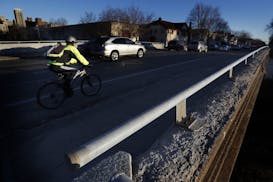 A cyclist and cars passed over the Midtown Greenway on the Portland Avenue Bridge in Minneapolis. The bridge is one of two that will be demolished thi