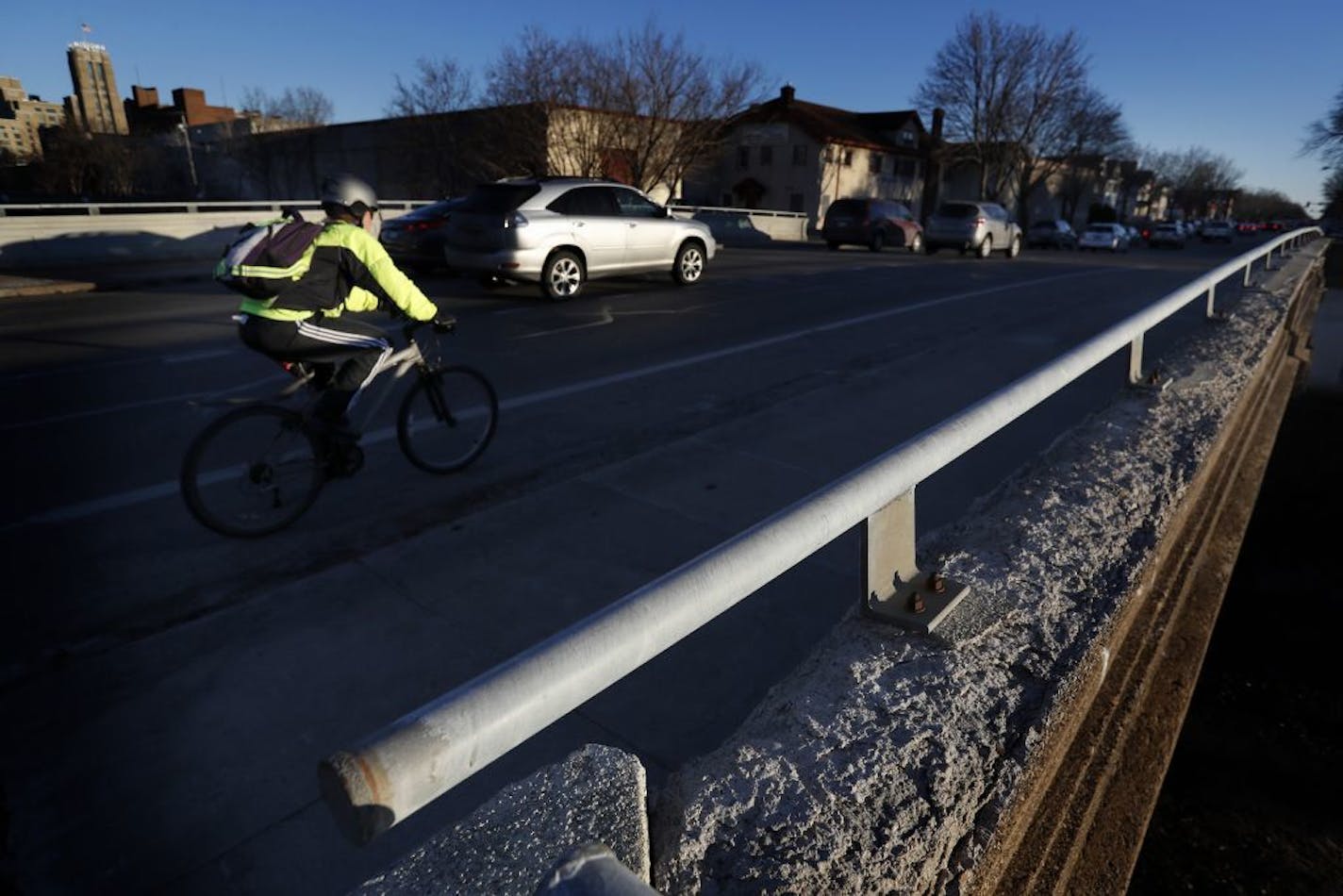 A cyclist and cars passed over the Midtown Greenway on the Portland Avenue Bridge in Minneapolis. The bridge is one of two that will be demolished this spring and replaced.