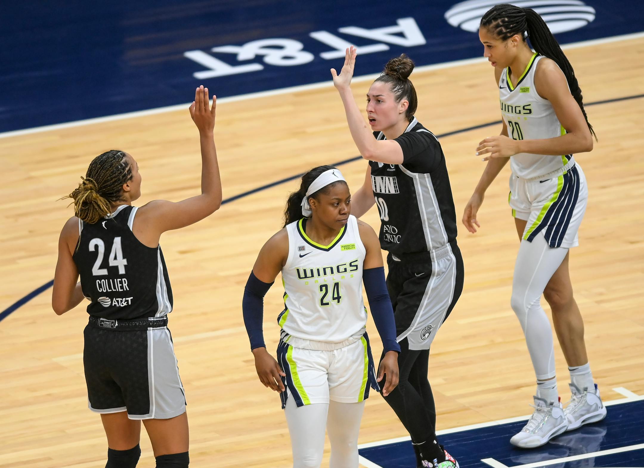 Minnesota Lynx forward Napheesa Collier (24) and forward Jessica Shepard (10) high fived after forcing a turnover off a shot clock violation late in the second half as Dallas Wings guard Arike Ogunbowale (24) and forward Isabelle Harrison (20) looked on in frustration.