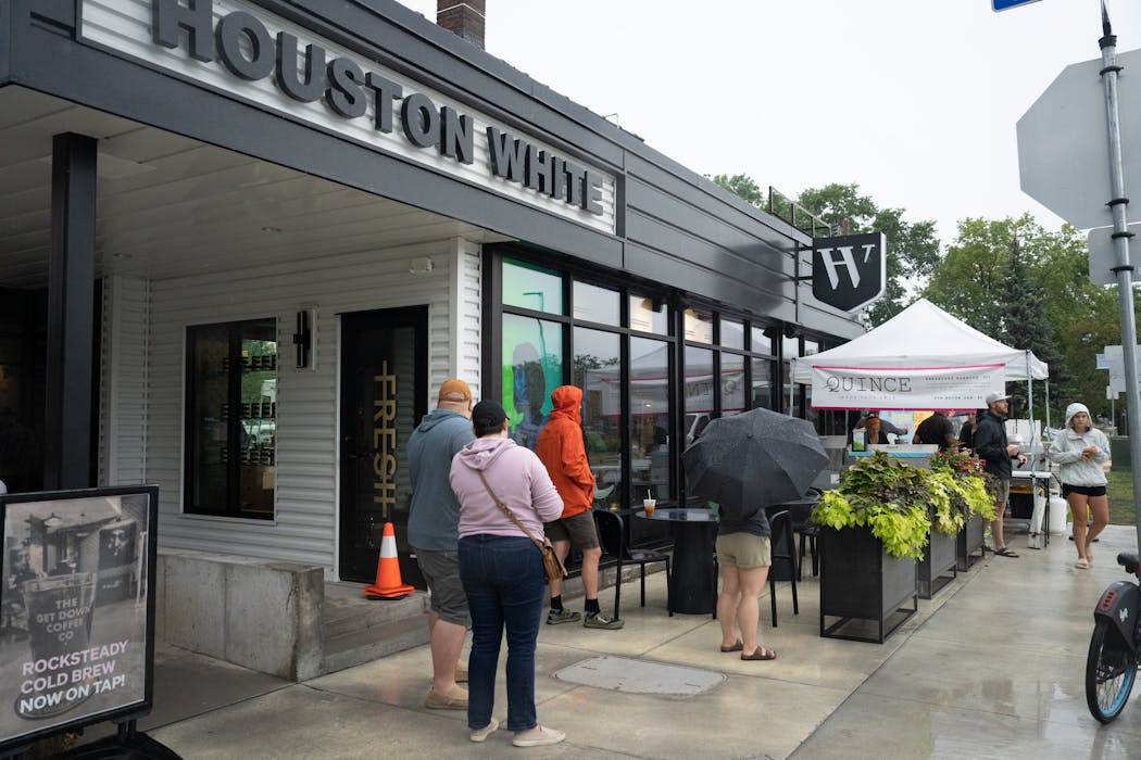 People lined up in the rain for burritos from Quince outside Houston White’s building.