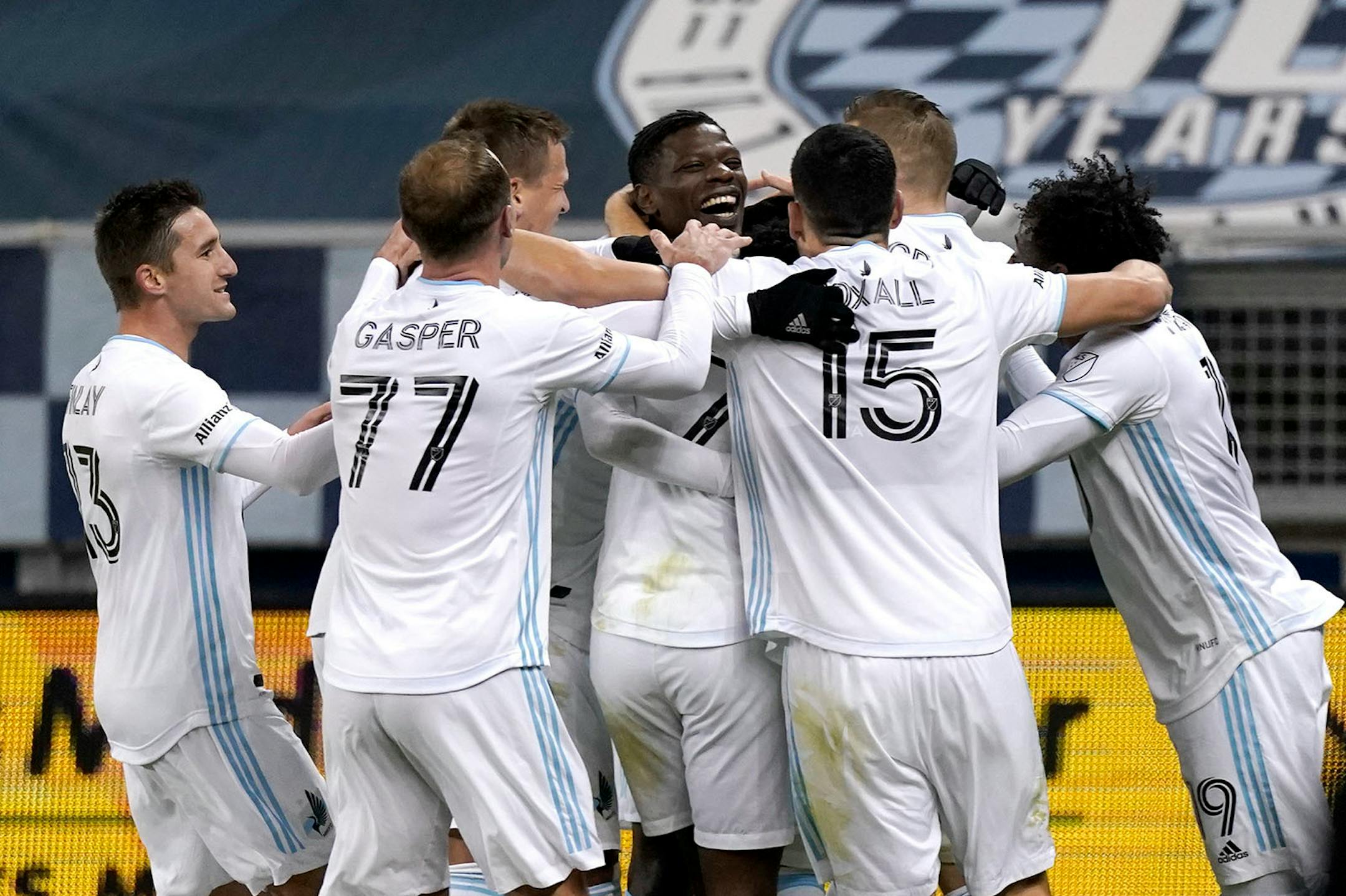 Minnesota United players celebrate after a goal by Bakaye Dibassy, center, during the first half of the team's MLS soccer match against Sporting Kansas City on Thursday, Dec. 3, 2020, Kansas City, Kan. (AP Photo/Charlie Riedel)