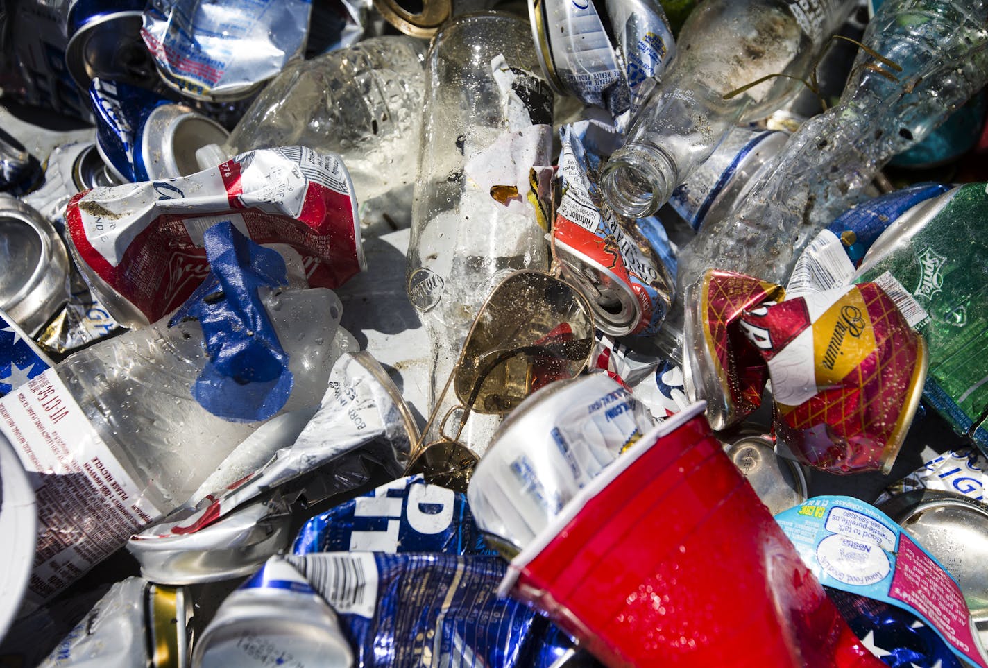 Various trash items, including a pair of sunglasses and many cans, bottles and cups, that have been collected in Lake Minnetonka after the July 4th weekend. ] (Leila Navidi/Star Tribune) leila.navidi@startribune.com BACKGROUND INFORMATION: Clean up near Big Island on Lake Minnetonka on July 5, 2016. Volunteers are increasing clean-up efforts on Lake Minnetonka after the rowdy July 4th holiday weekend results in boatloads of trash. On Tuesday, Hennepin County Sheriff's Office divers will join the