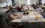 Hennepin County election workers Timonthy Hart, left, and Olivia Reyes, right, counted absentee ballots for the primary election, Monday, August 10, 2