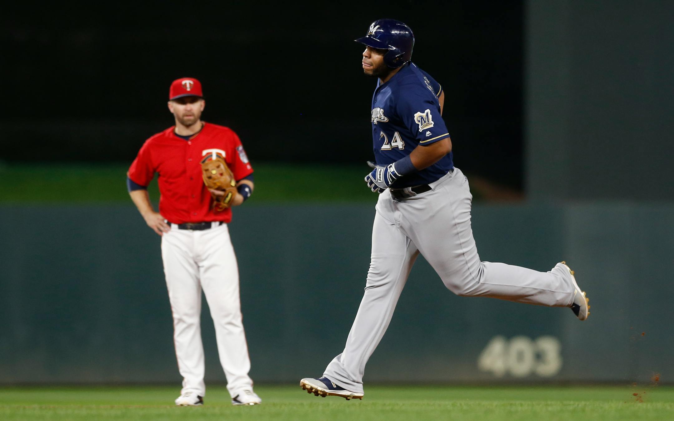 Milwaukee Brewers' Jesus Aguilar, right, rounds the bases on a solo home run as Minnesota Twins' second baseman Brian Dozier watches in the seventh inning of a baseball game Friday, May 18, 2018, in Minneapolis. (AP Photo/Jim Mone)