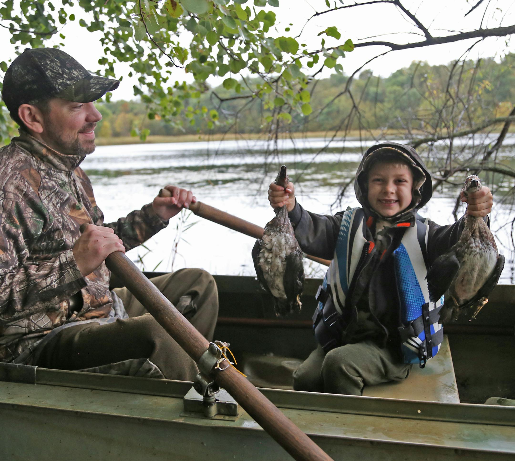 Five-year-old Jordan Strand, with his dad, Mike, proudly holds two wood ducks taken Saturday morning near New London on the Minnesota waterfowl season opener.