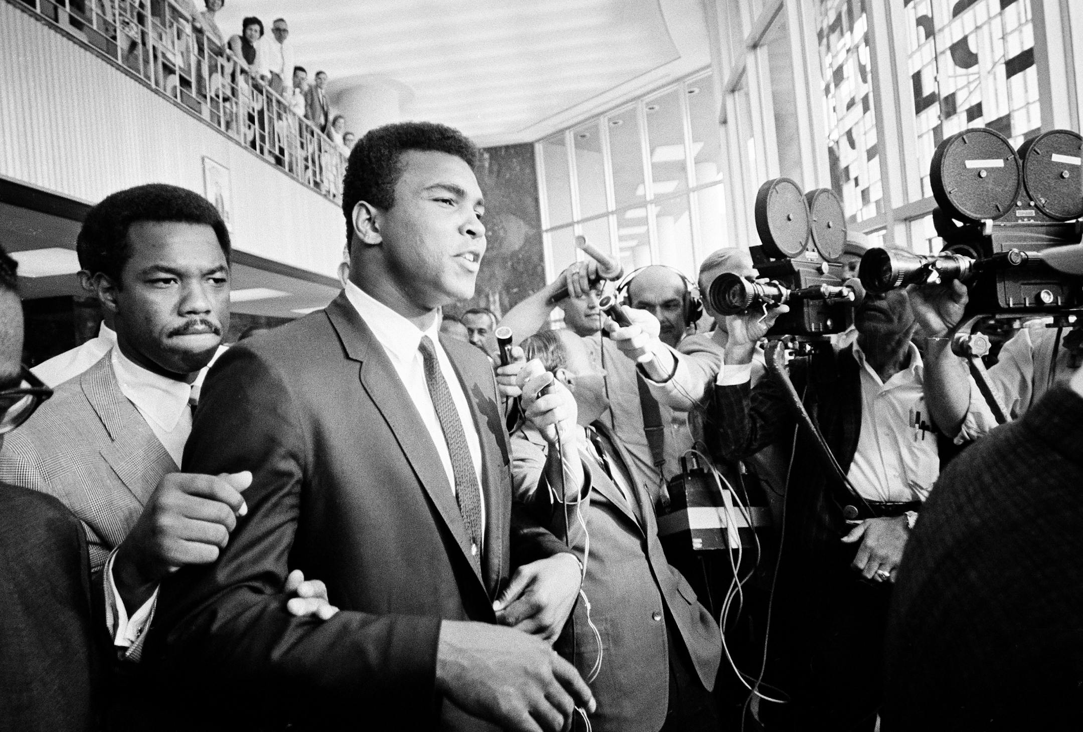 Heavyweight champion Muhammad Ali has a "no comment" as he is confronted by newsmen as he leaves the Federal Building in Houston for lunch during the noon recess of court, June 19, 1967. Ali's trial, on a federal indictment charging he refused to be inducted into the Armed Services, started today.