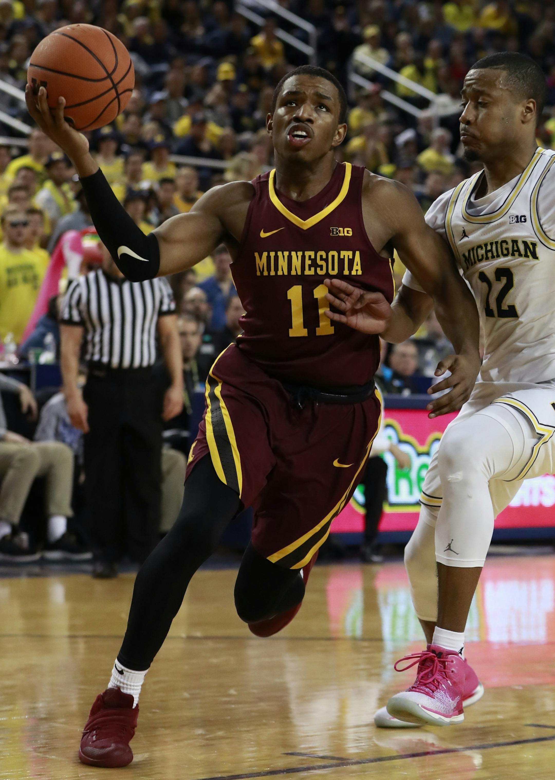 Minnesota guard Isaiah Washington (11) drives to the basket as Michigan guard Muhammad-Ali Abdur-Rahkman (12) defends during the first half of an NCAA college basketball game, Saturday, Feb. 3,2018, in Ann Arbor, Mich. (AP Photo/Carlos Osorio)
