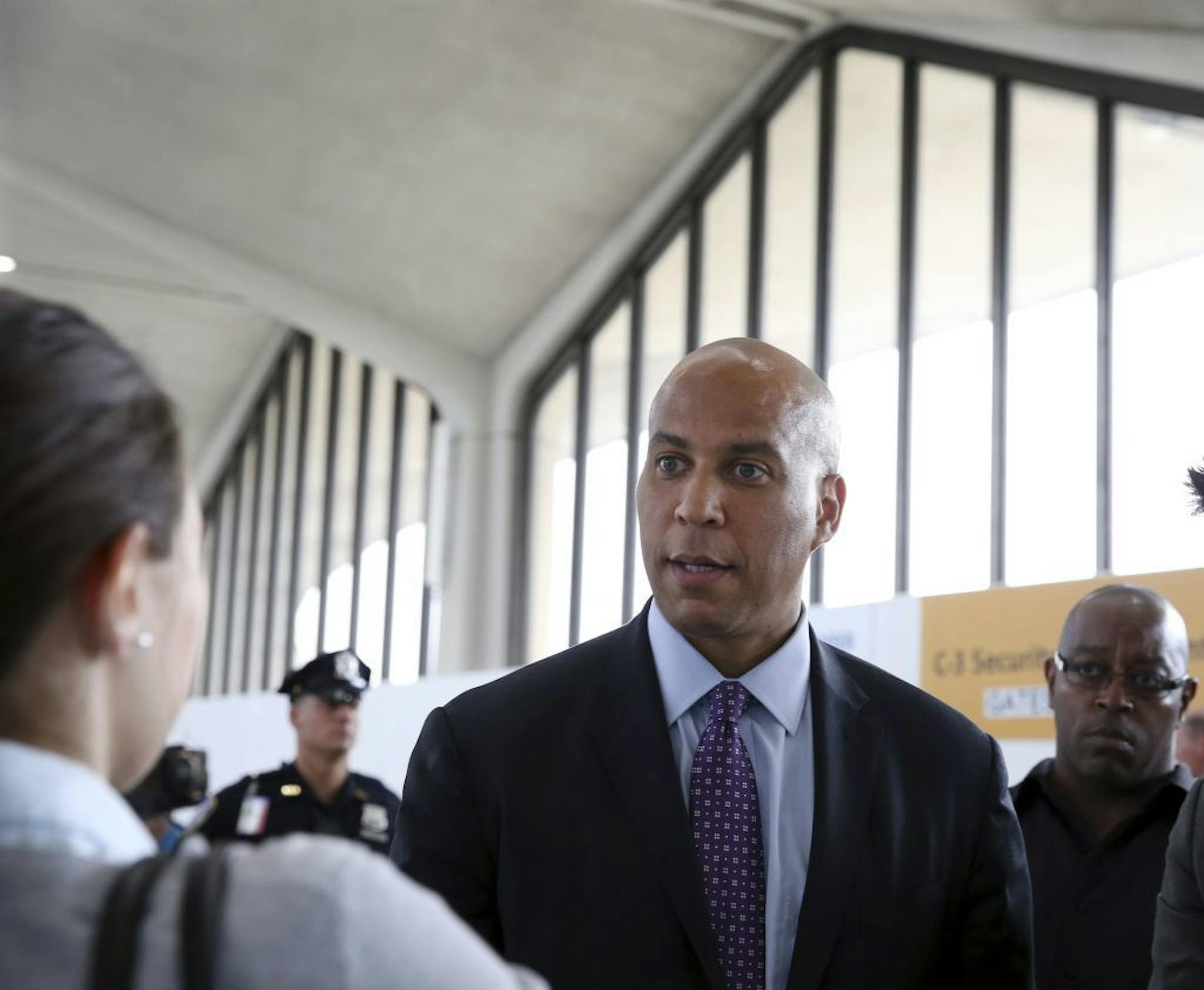 Sen. Cory Booker, D-N.J., greets people as he walks in Newark Liberty International airport after he and Sen. Bob Menendez, D-N.J., along with others, announced that the Transportation Security Administration is adding more than 100 more agents to help ease security lines at the airport by the end of the month Monday, May 23, 2016 in Newark, N.J.