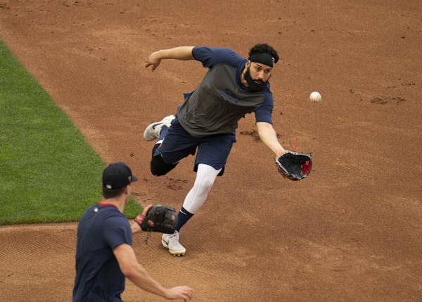 Minnesota Twins infielder Marwin Gonzalez (9) tossed a ball he fielded to relief pitcher Trevor May (65) during a drill Monday afternoon.