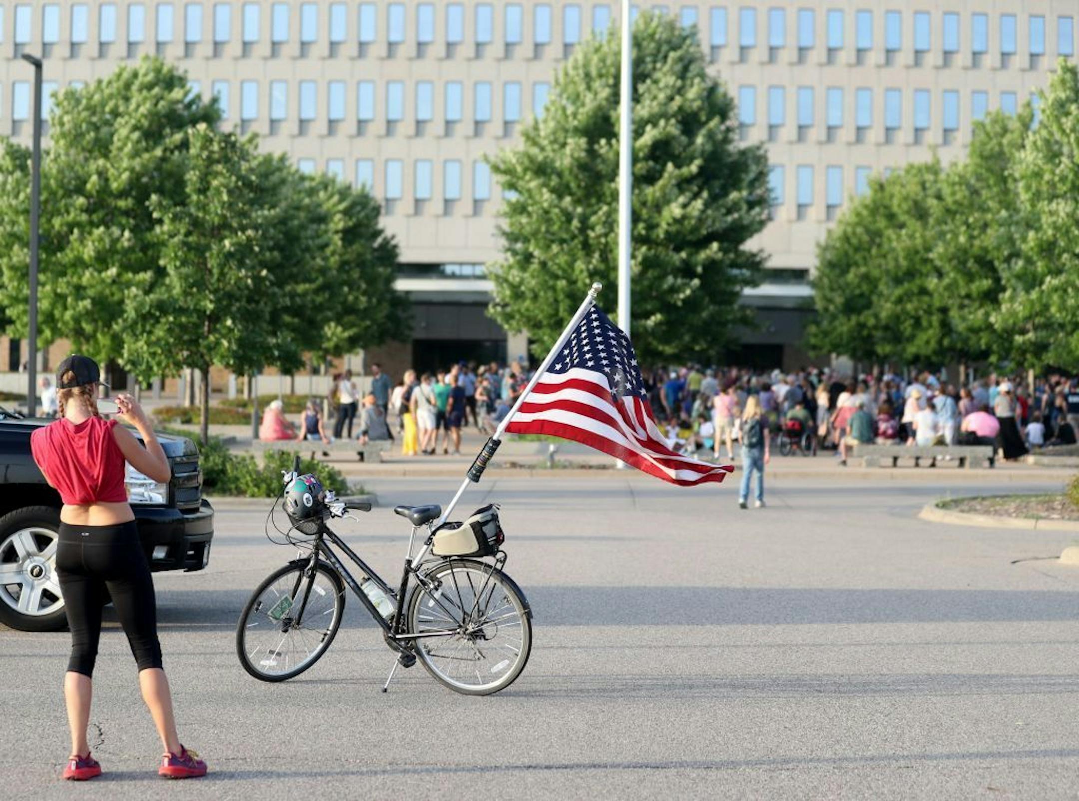 Joldy Wynen of Minneapolis photographed her bike with the flag before the start of the Lights for Liberty vigil outside the Whipple Federal Building at Fort Snelling on Friday.